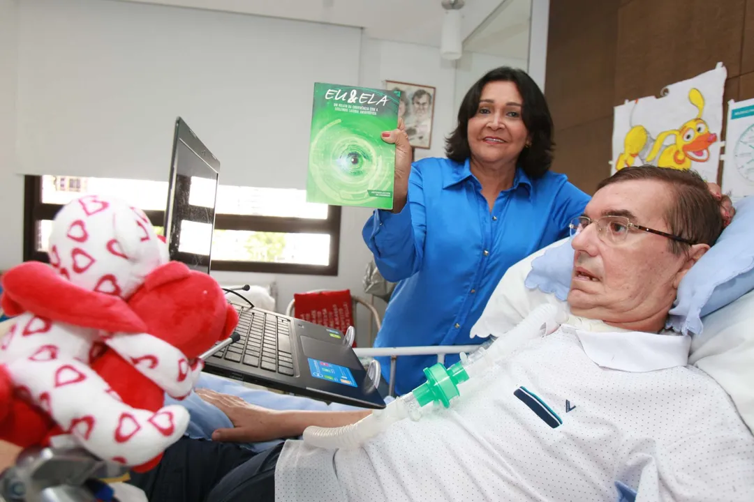 Antônio Ailton de Andrade ao lado da esposa, Regina, que segura o livro dele