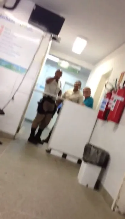 Na imagem retirada do vídeo, PM aparece em um balcão ao lado de dois homens
