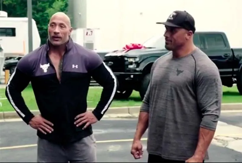 The Rock aparece ao lado do dublê Tanoai Reed e o carro ao fundo
