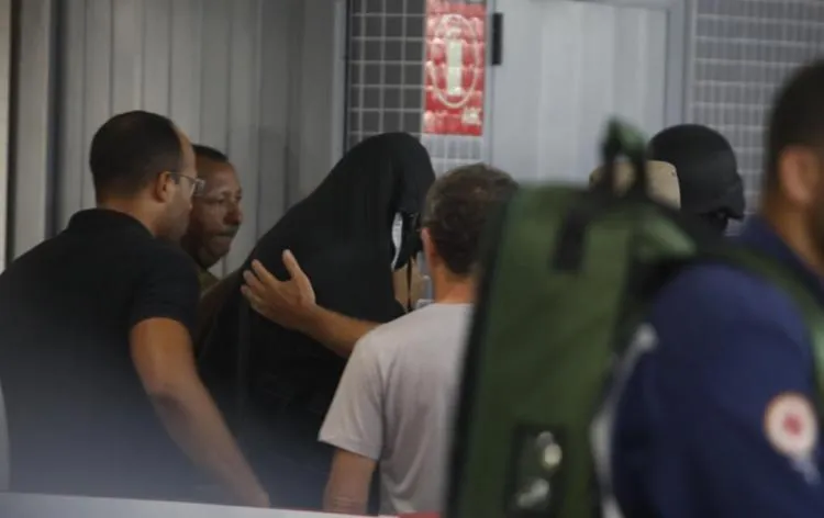 Homem que manteve refém saiu da Estação Acesso Norte com uma manta preta e acompanhado pela polícia | Foto: Felipe Iruatã | Ag. A TARDE