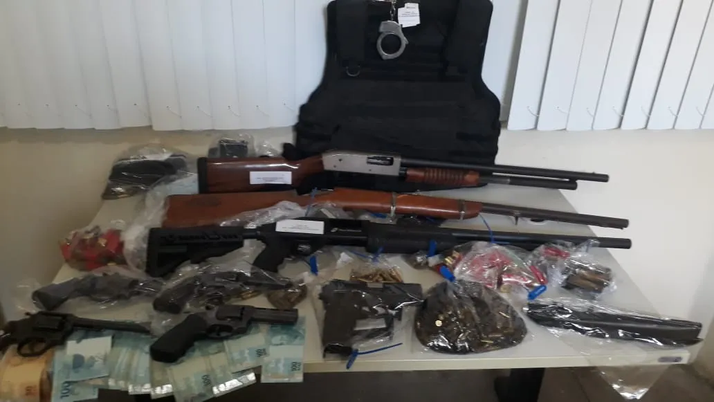 Foram encontrados quatro revólveres calibre 38, uma pistola, três espingardas, carregador, munições, colete balístico, algema e celulares | Foto: Divulgação | SSP