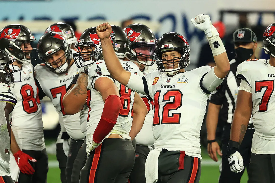 Aos 43 anos, o 'quarterback' (camisa 12) aumentou ainda mais sua lenda ao vencer o duelo de gerações contra aquele que é considerado seu sucessor, Patrick Mahomes | Foto: Mike Ehrmann | AFP