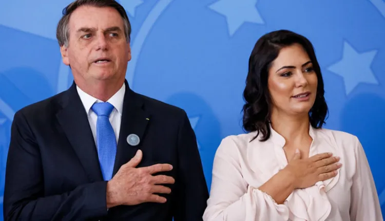 Jair Bolsonaro (esq.) e primeira-dama Michelle Bolsonaro (dir.) cantam hino nacional