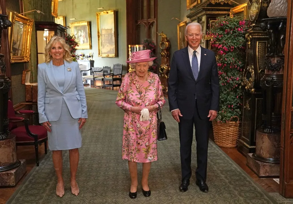 Com um vestido floral e um chapéu rosa, a monarca deu as boas-vindas ao presidente americano e à primeira-dama, Jill Biden | Foto: Steve Parsons | Pool | AFP