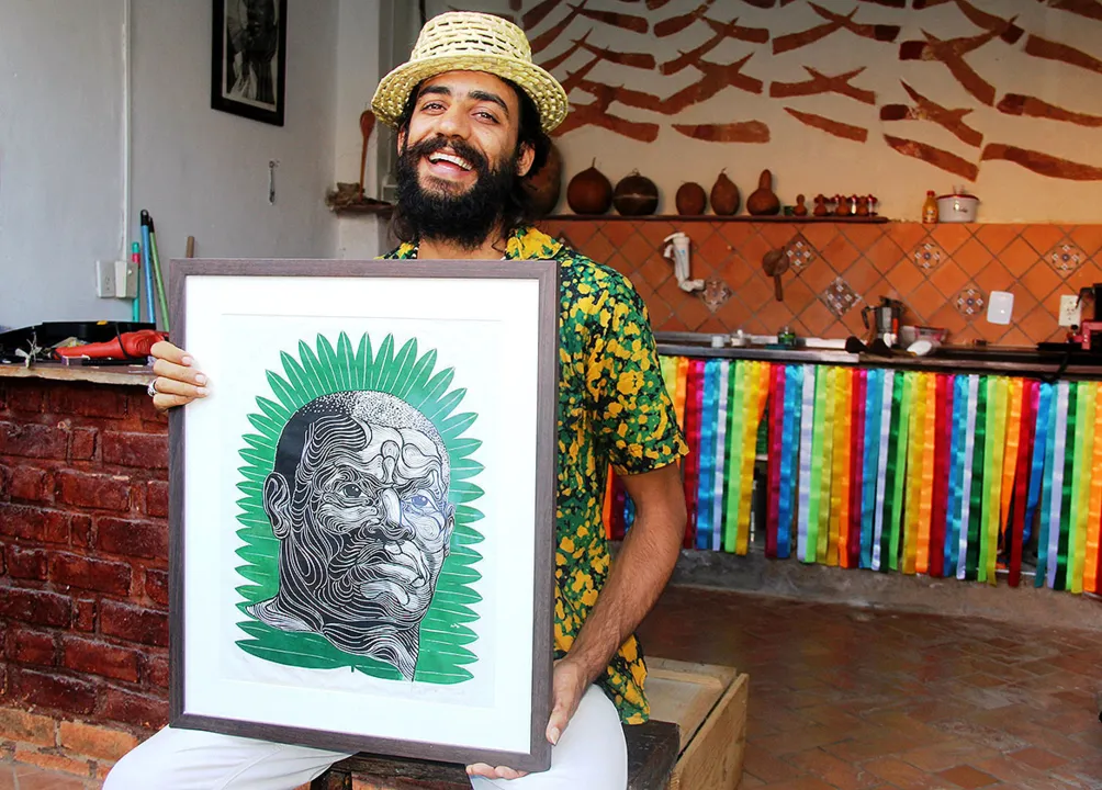 Artur Soares, em Lençóis, segura quadro com imagem de Zumbi dos Palmares | Foto: Rita Tavares | Divulgação