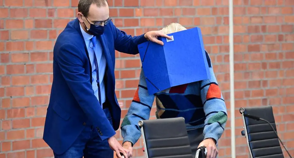 O réu Josef Schutz esconde o rosto atrás de uma pasta quando chega para seu julgamento em Brandenburg | Foto: Tobias Schwarz | AFP