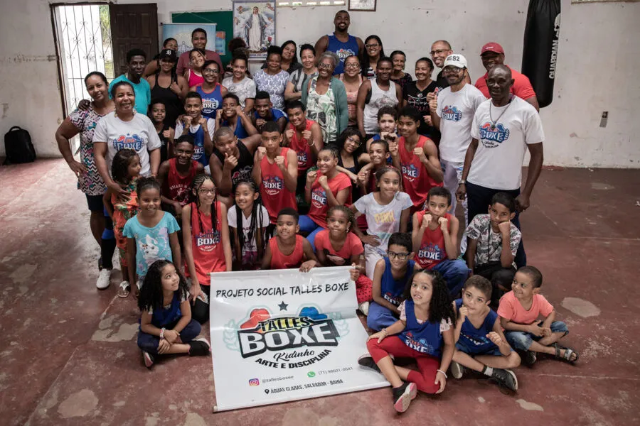 Kidinho, professor e  fundador da Talles Boxe, com a criançada e a equipe na academia