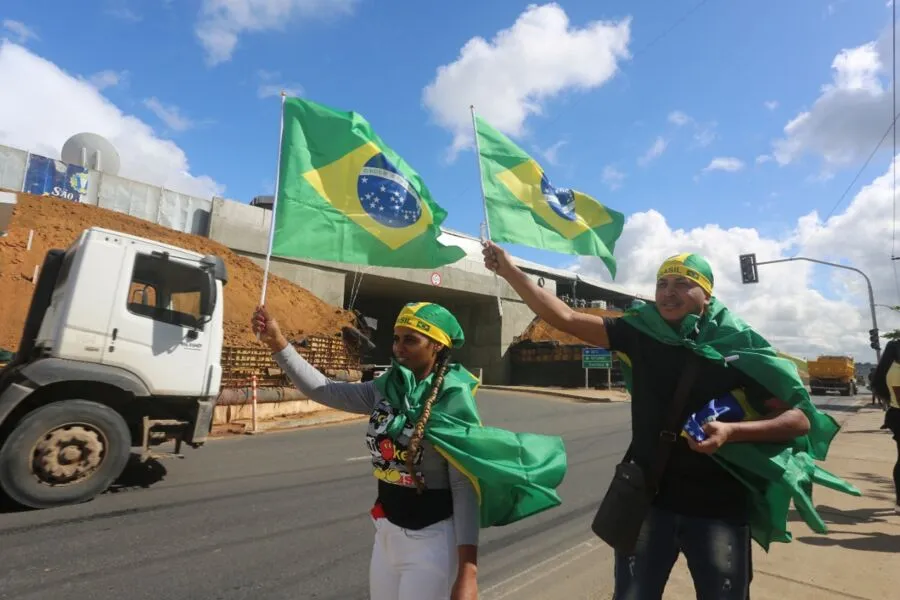 Dupla vende bandeiras e bandanas do Brasil e máscaras com imagem do rosto de Bolsonaro