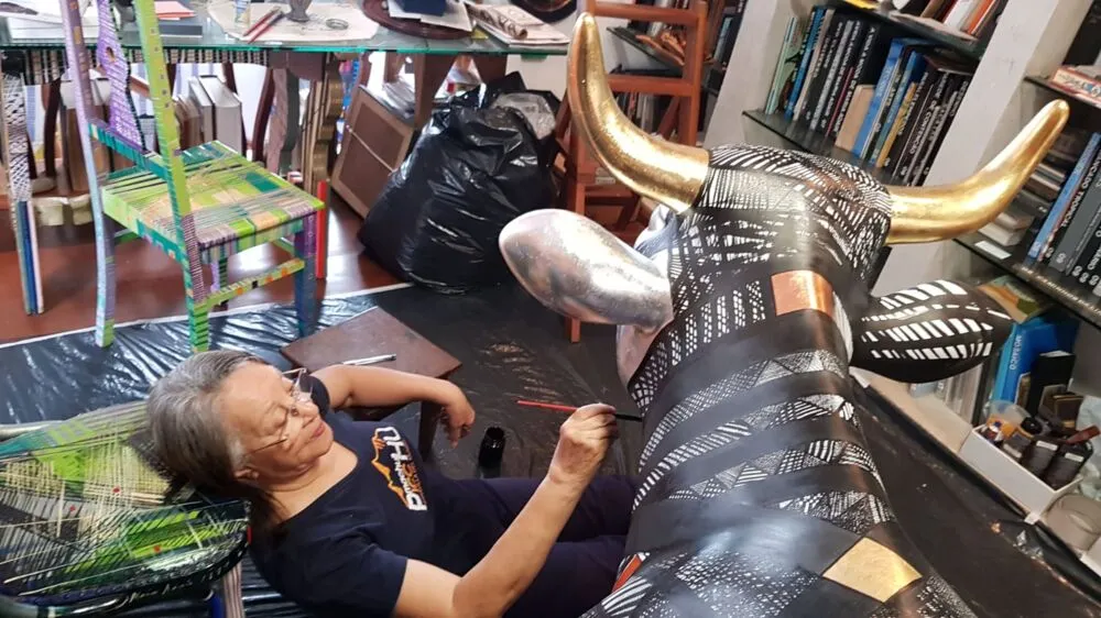Maria Adair pintando a vaca de resina para a cow parede de Salvador