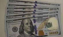 Imagem ilustrativa da imagem Dólar cai para R$ 5,11 com exterior e Copom