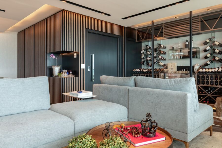 Sala de estar com porta de entrada e outros elementos na cor preta, em projeto do arquiteto Edilson Campelo