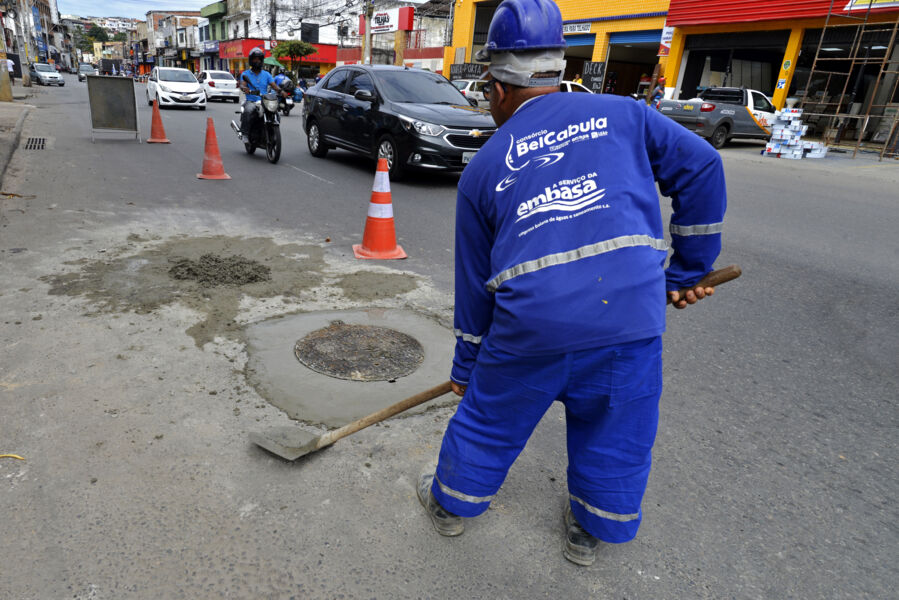 Funcionário da Embasa realizando conserto da via e fazendo reposição da tampa do bueiro que tinha sido roubada na avenida San Martin