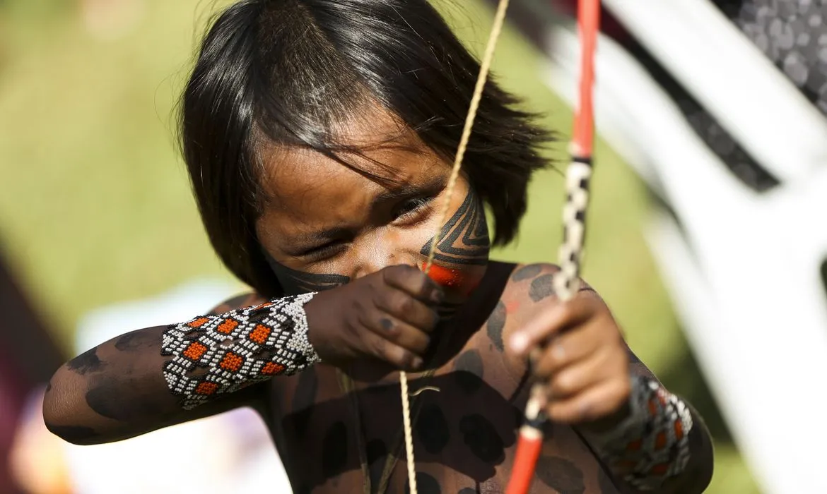 Criança Yanomami segurando um arco