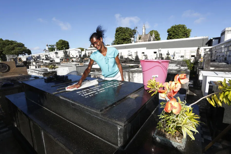 Hermínia de Jesus trabalha há 19 anos limpando túmulos. Atualmente possui 13 para cuidar