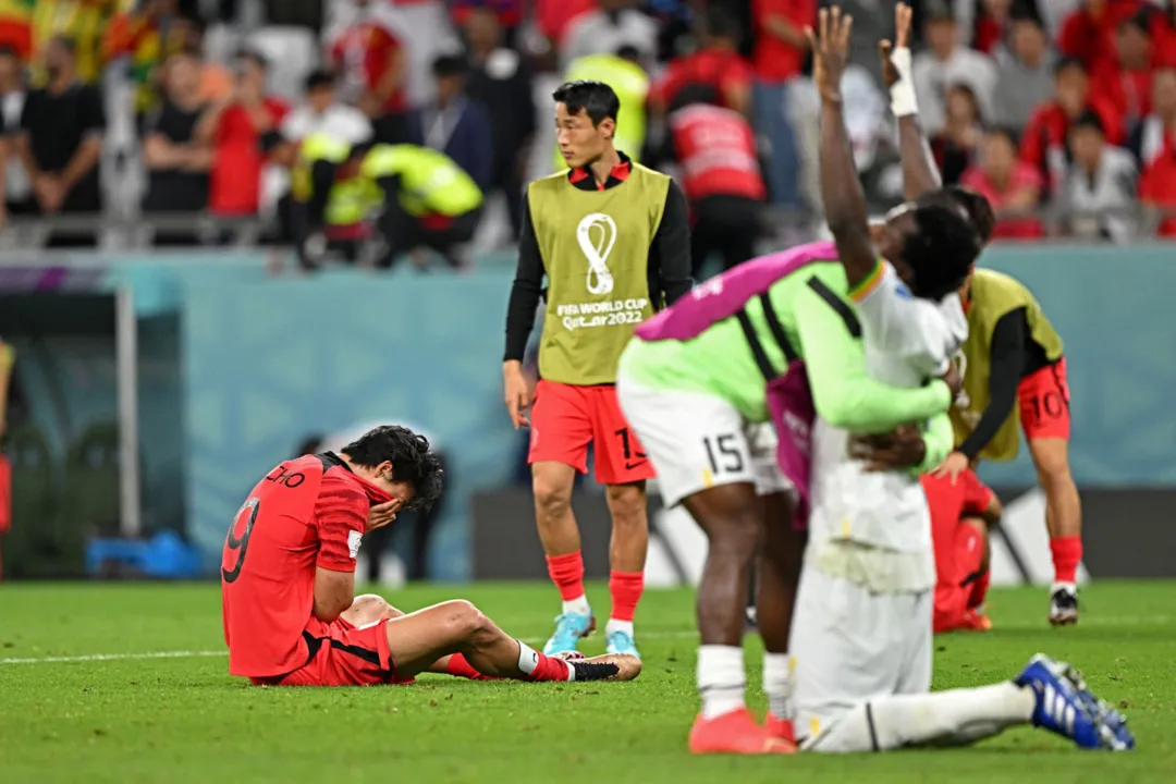 Jogadores de Gana comemoram e da Coréia do Sul lamentam o resultado do jogo