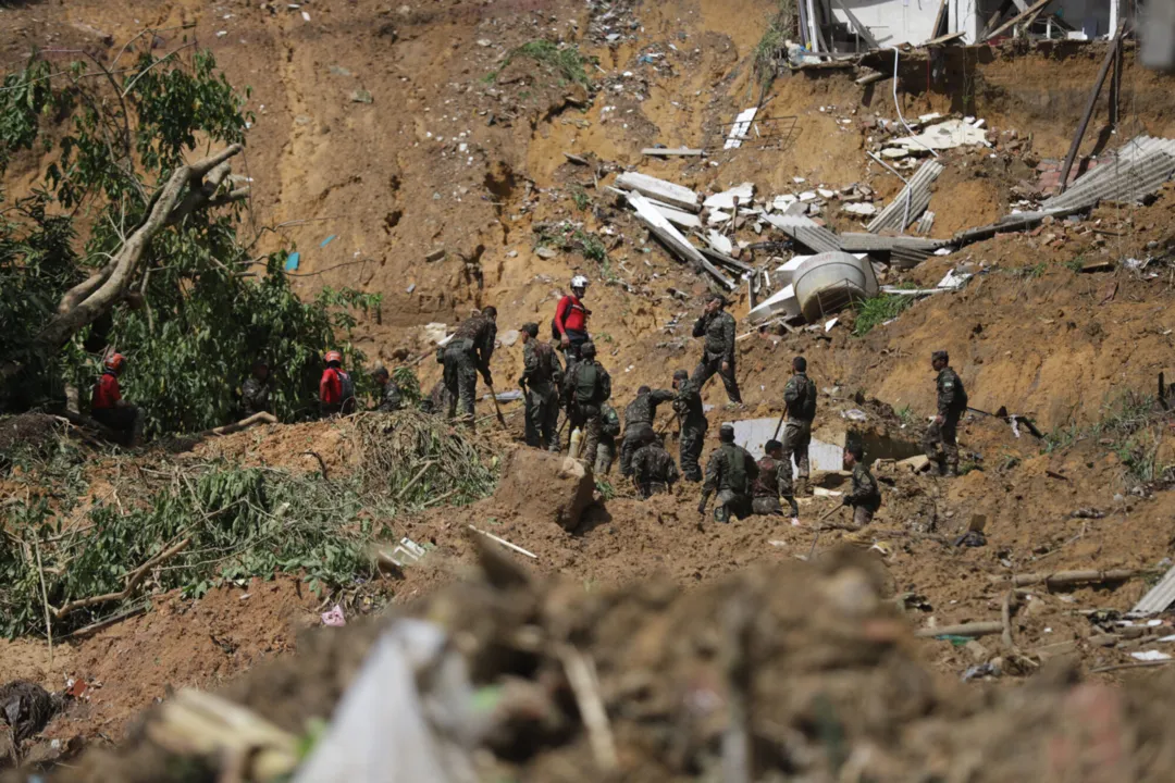 Bombeiros e soldados do Exército Brasileiro procuram vítimas de deslizamento de terra na comunidade Bola de Ouro, município de Jaboatão dos Guararapes, estado de Pernambuco