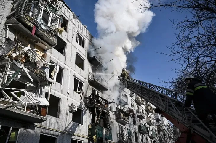 Bombeiros controlam incêndio em um prédio após bombardeios na cidade de Chuhuiv, no leste da Ucrânia, em 24 de fevereiro de 2022