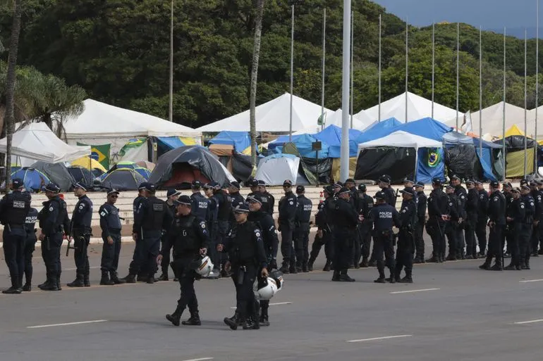 Depois de terem supostamente facilitado o acesso aos prédios da Praça dos Três Poderes, Polícia do DF se concentra em frente ao acampamento golpista