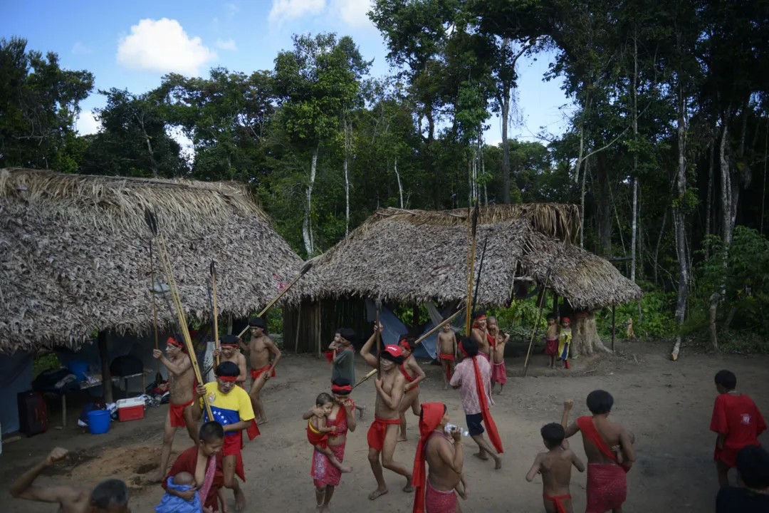 Yanomami natives perform a ritual dance at Irotatheri community, in Amazonas state, southern Venezuela, 19 km away from the border with Brazil, on September 7, 2012. The Venezuelan government on Friday agreed to lead a delegation of national and international media to Irotatheri after a slaughter of 80 Yanomami natives was reported. Venezuelan militarymen detected evidence of illegal mining in the south of the country, where Yanomami natives would have presumably been massacred by Brazilian illegal gold prospectors. AFP PHOTO/Leo RAMIREZ (Photo by LEO RAMIREZ / AFP)