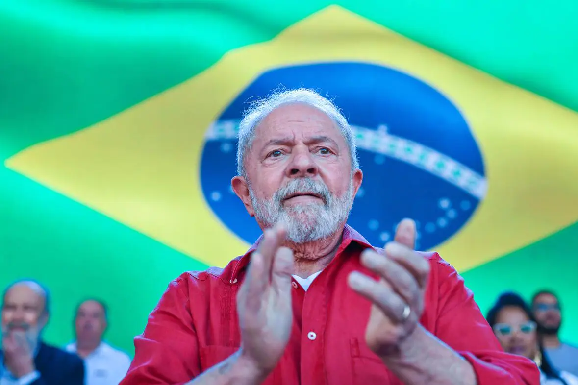 Presidente Lula, do PT, com a bandeira do Brasil ao fundo