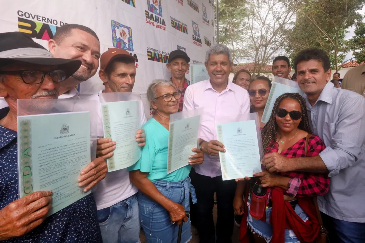 O governador Jerônimo Rodrigues entregando títulos de regulação fundiária para famílias em Santa Bárbara
