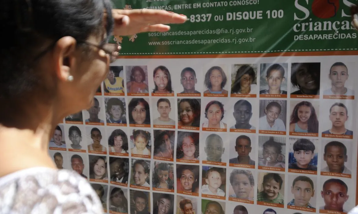 Mural de fotos de pessoas desaparecidas no Brasil