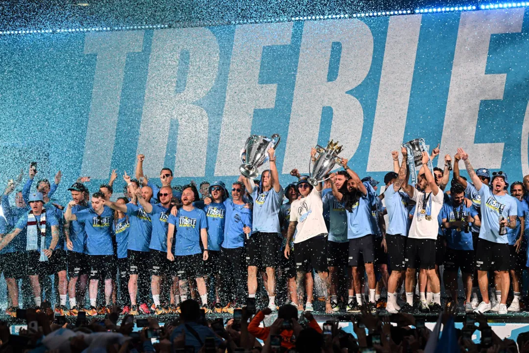 Jogadores e torcedores do Manchester City comemoram tríplice coroa