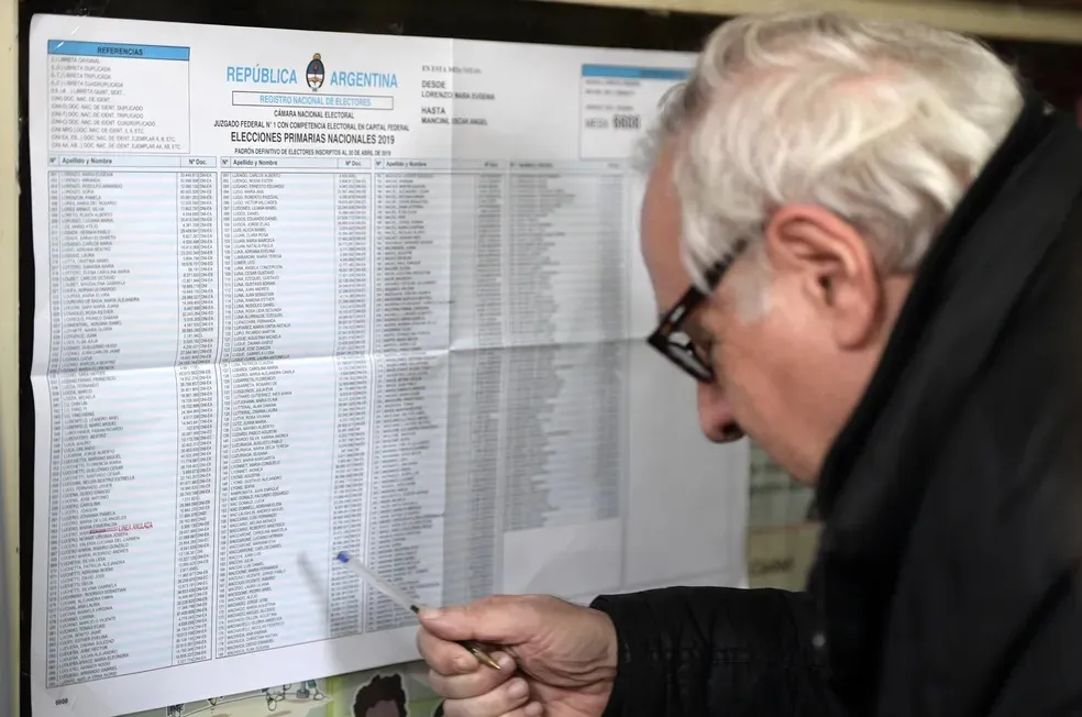Eleitor checando listas de candidatos em dia de eleições prévias na Argentina