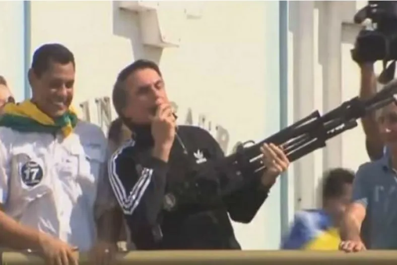 Bolsonaro segurou um tripé de uma câmera de vídeo, simulando o uso de uma arma de fogo