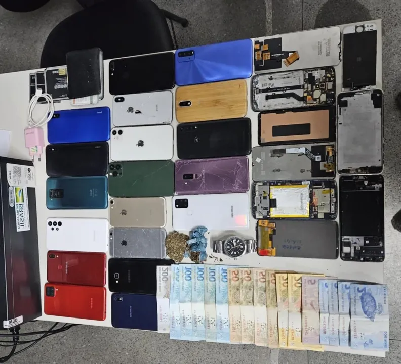 Foram encontrados, 19 smartphones, 2 porções de maconha, 3 baterias de celulares, aparelhos celulares desmontados e 1 relógio
