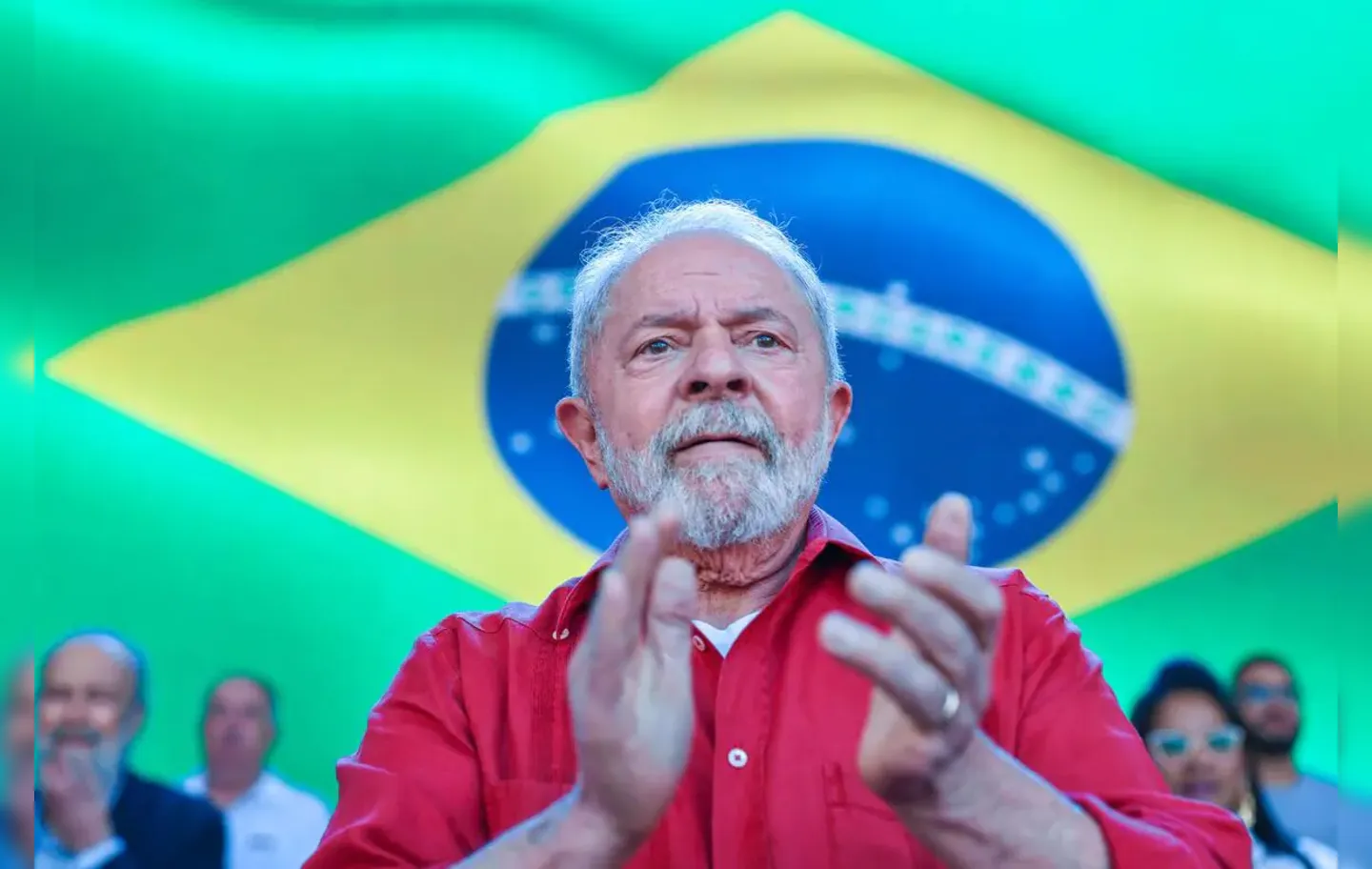 Presidente Lula, do PT, com a bandeira do Brasil ao fundo
