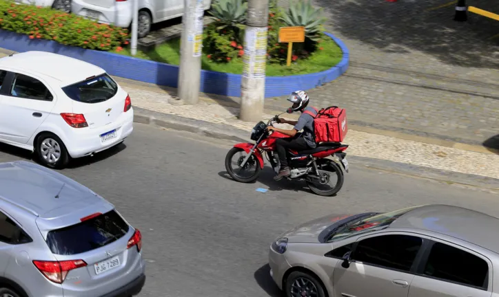Entregador de comida com moto, visto na Avenida Tancredo Neves em Salvador