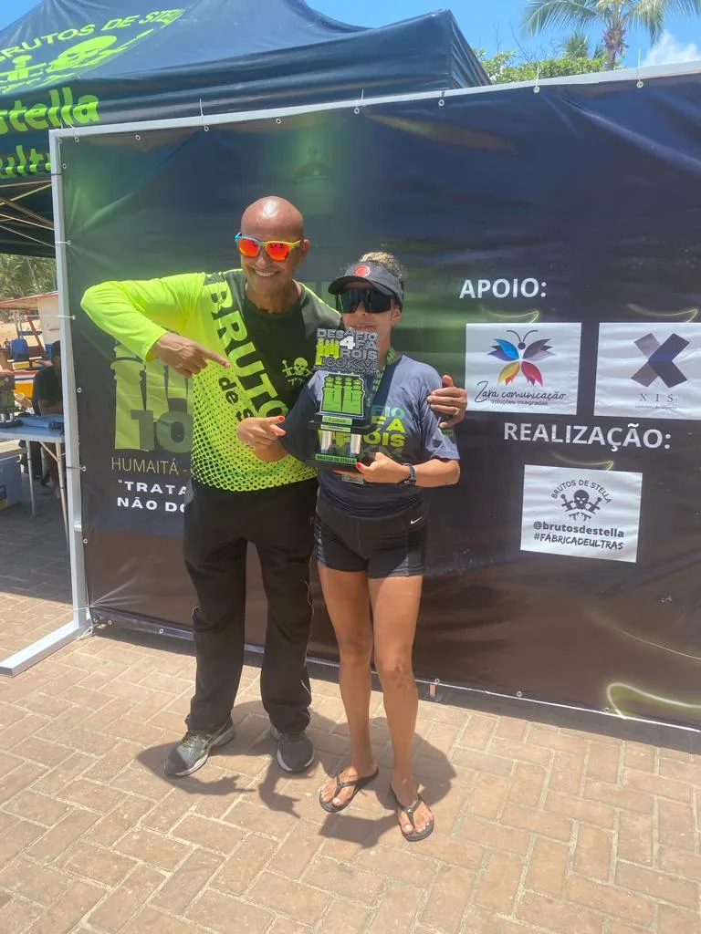 Lídia Oliveira, 47 anos, recebendo seu troféu como a vencedora da ultramaratona de 100 km