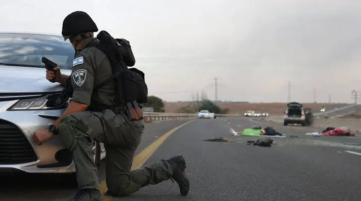 Soldado israelense usa carro como escudo e observa corpos na pista