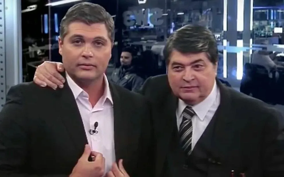 Joel [à esq.] está substituindo o pai no telejornal da Band