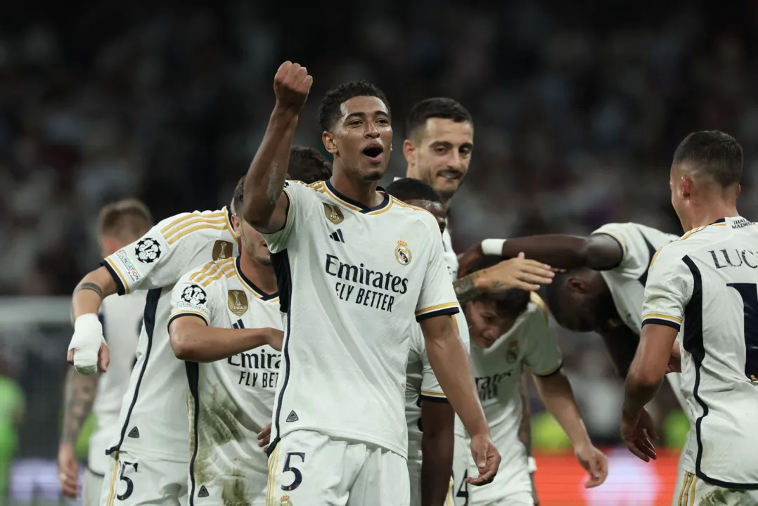 Real Madrid's English midfielder #5 Jude Bellingham celebrates with teammates scoring his team's first goal during the UEFA Champions League 1st round day 1 group C football match between Real Madrid and Union Berlin at the Santiago Bernabeu stadium in Madrid on September 20, 2023. (Photo by Thomas COEX / AFP)