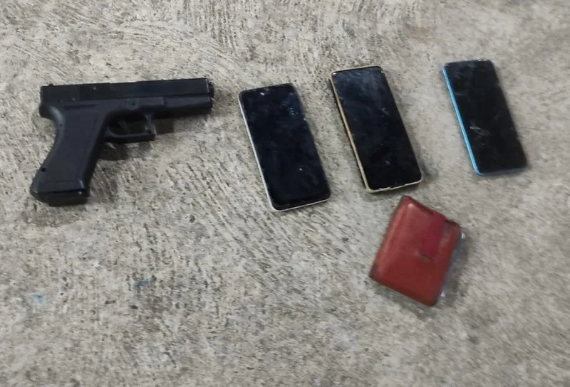 Uma réplica de pistola e três celulares foram apreendidos com os suspeitos