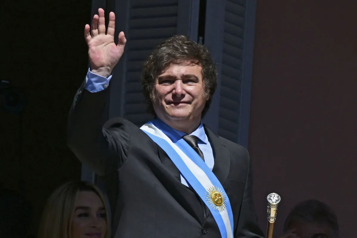 Argentina's new president Javier Milei waves at the crowd from a balcony of the Casa Rosada government palace during his inauguration day in Buenos Aires on December 10, 2023. Libertarian economist Javier Milei was sworn in Sunday as Argentina's president, after a resounding election victory fuelled by fury over the country's economic crisis. (Photo by Pablo PORCIUNCULA / AFP)