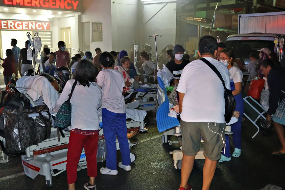 Residents and medical personnel evacuate patients from inside a hospital after a 7.6 earthequake struck Butuan City, in southern island of Mindanao late December 2, 2023. A powerful magnitude 7.6 earthquake struck the southern Philippines on December 2, the US Geological Survey said, as local authorities warned of a "destructive tsunami" and urged people in coastal areas to flee. (Photo by Ted ALJIBE / AFP)