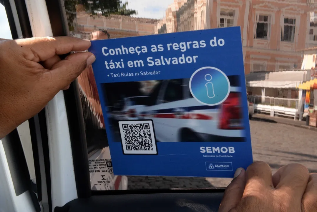 Adesivo está sendo colocado dentro dos veículos, no banco de trás, e conta com um QR Code que direciona o passageiro para uma lista de regras