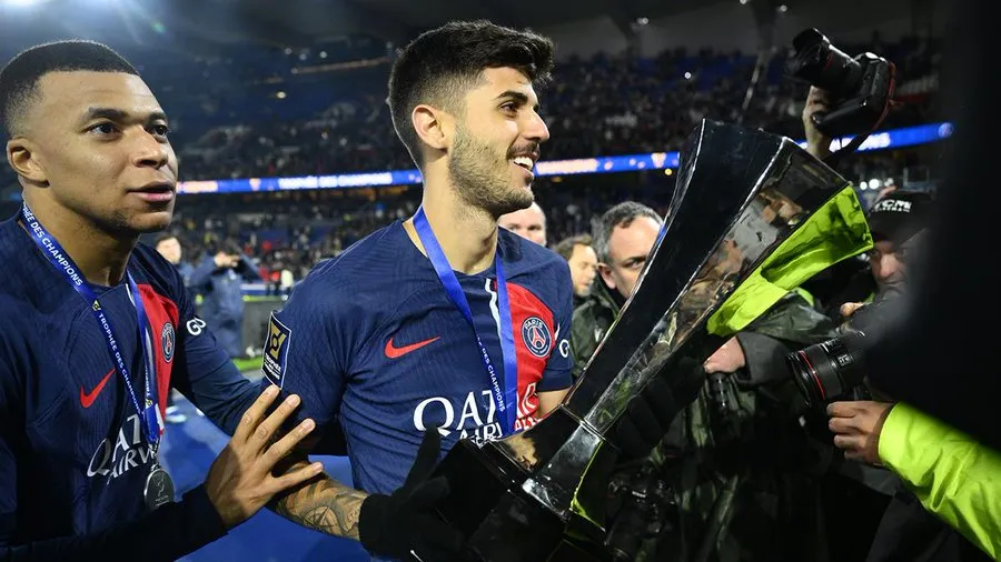 Lucas Beraldo ao lado de Mbappé, com o troféu da Supercopa da França