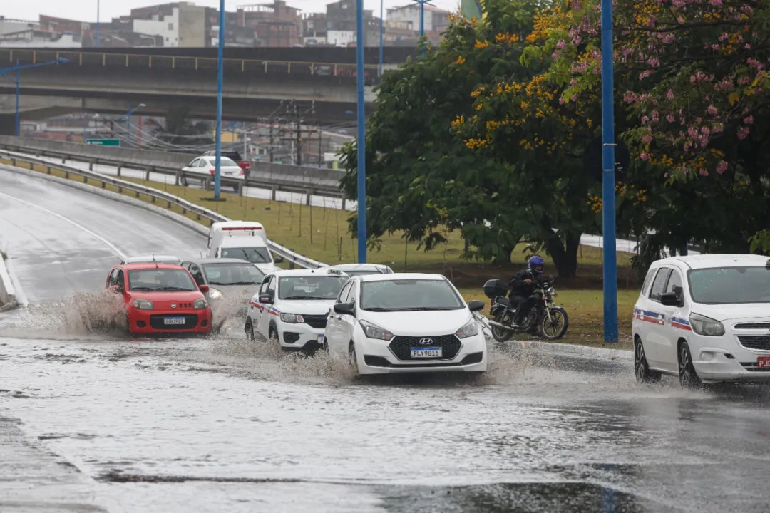 Carros passam por avenida alagada em Salvador
