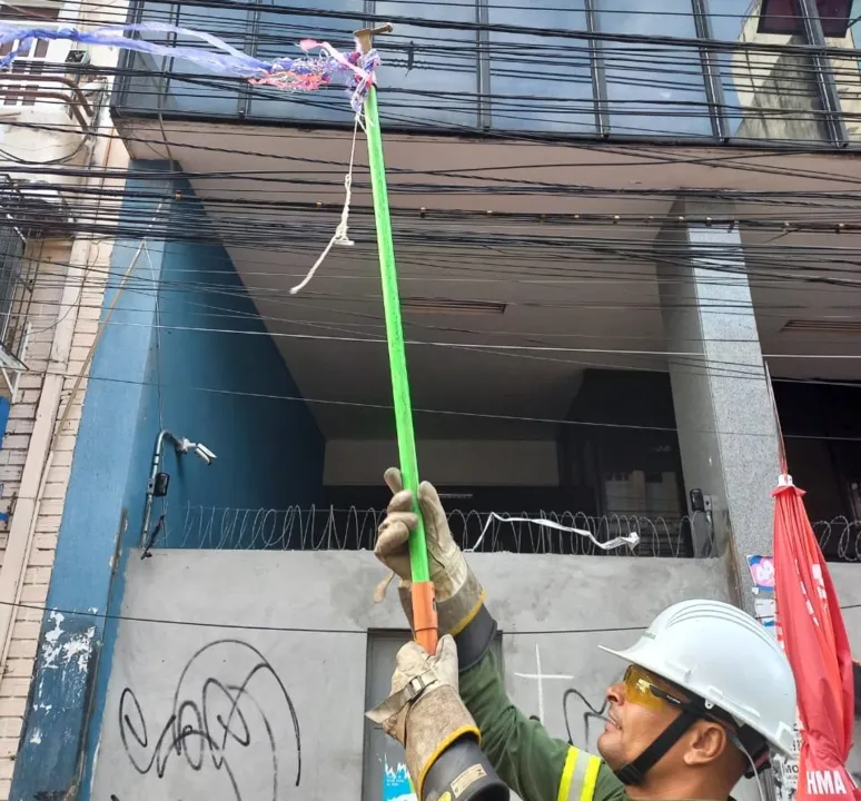 Equipes da Coelba atuam removendo serpentinas dos fios da rede elétrica.