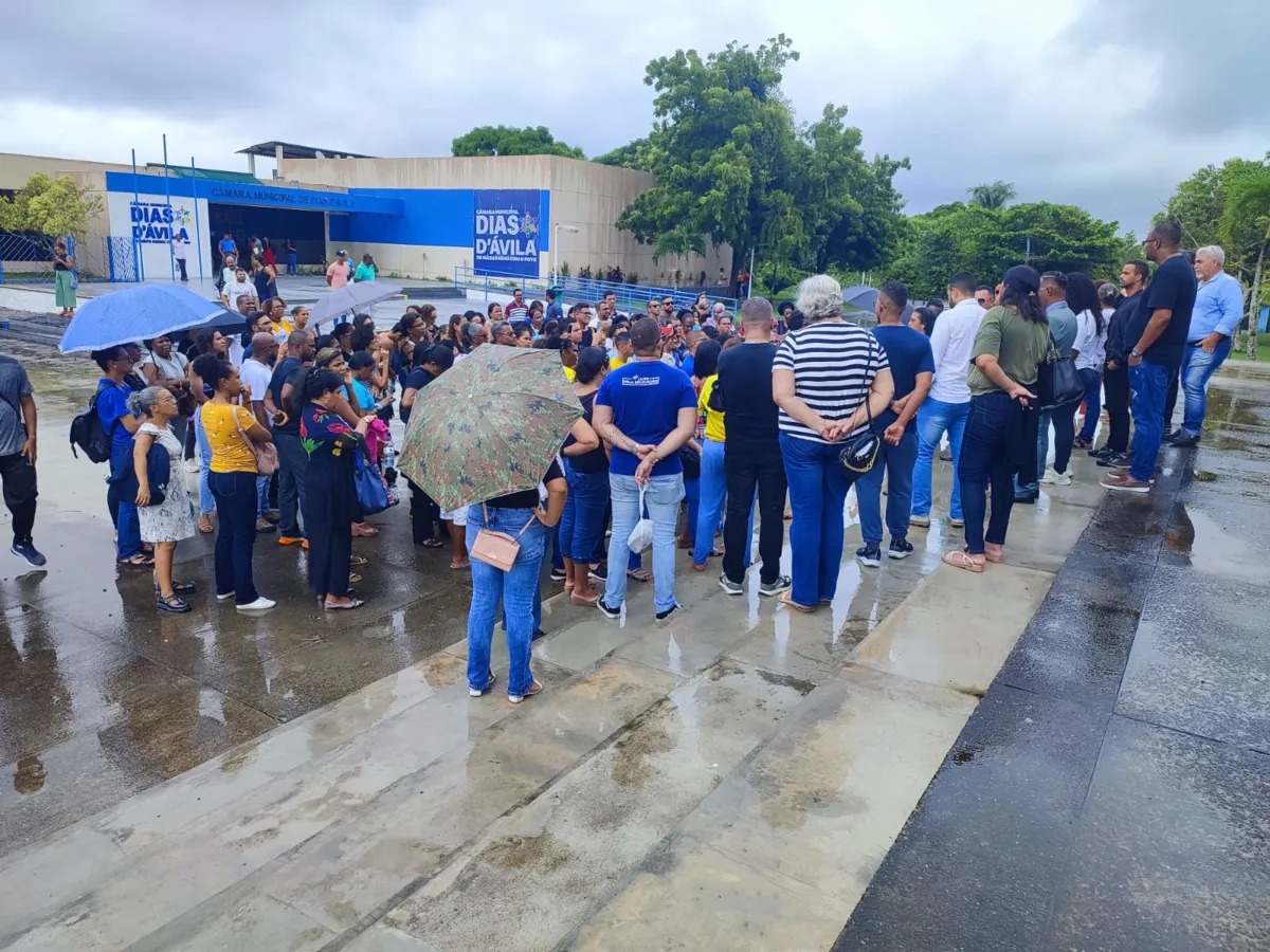 Professores se reúnem debaixo de chuva em frente à Câmara Municipal. Prefeitura negou espaço para assembleia.