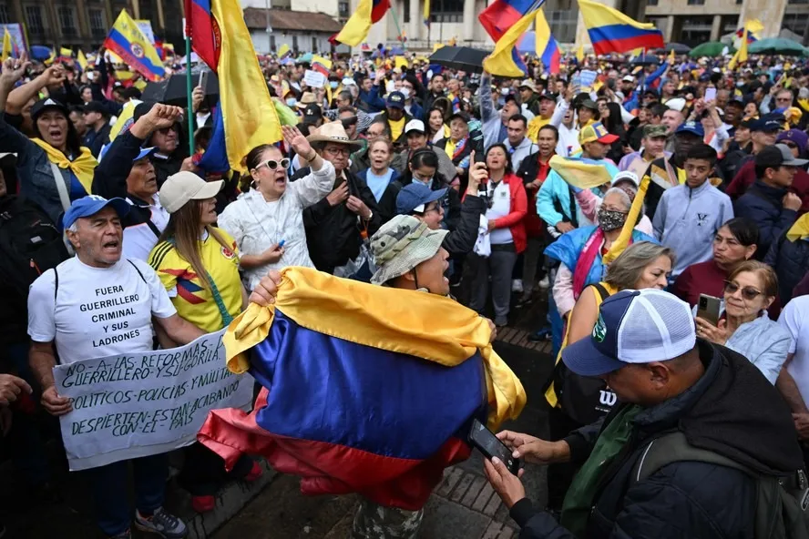 Pessoas seguram bandeiras da Colômbia durante uma manifestação contra o governo