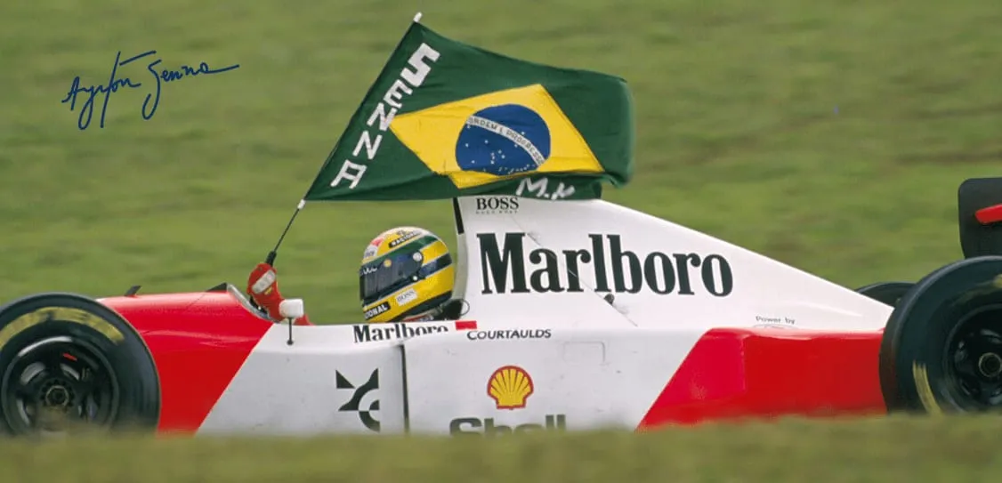 Piloto Ayrton Senna com a bandeira do Brasil após vencer corrida de Fórmula 1