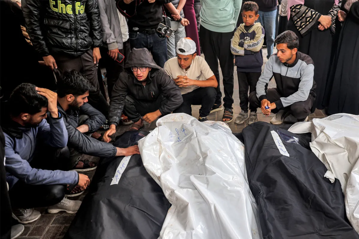Jovens choram pelos corpos de parentes que foram mortos na noite anterior durante o bombardeio israelense, no hospital Al-Najjar em Rafah, no sul da Faixa de Gaza