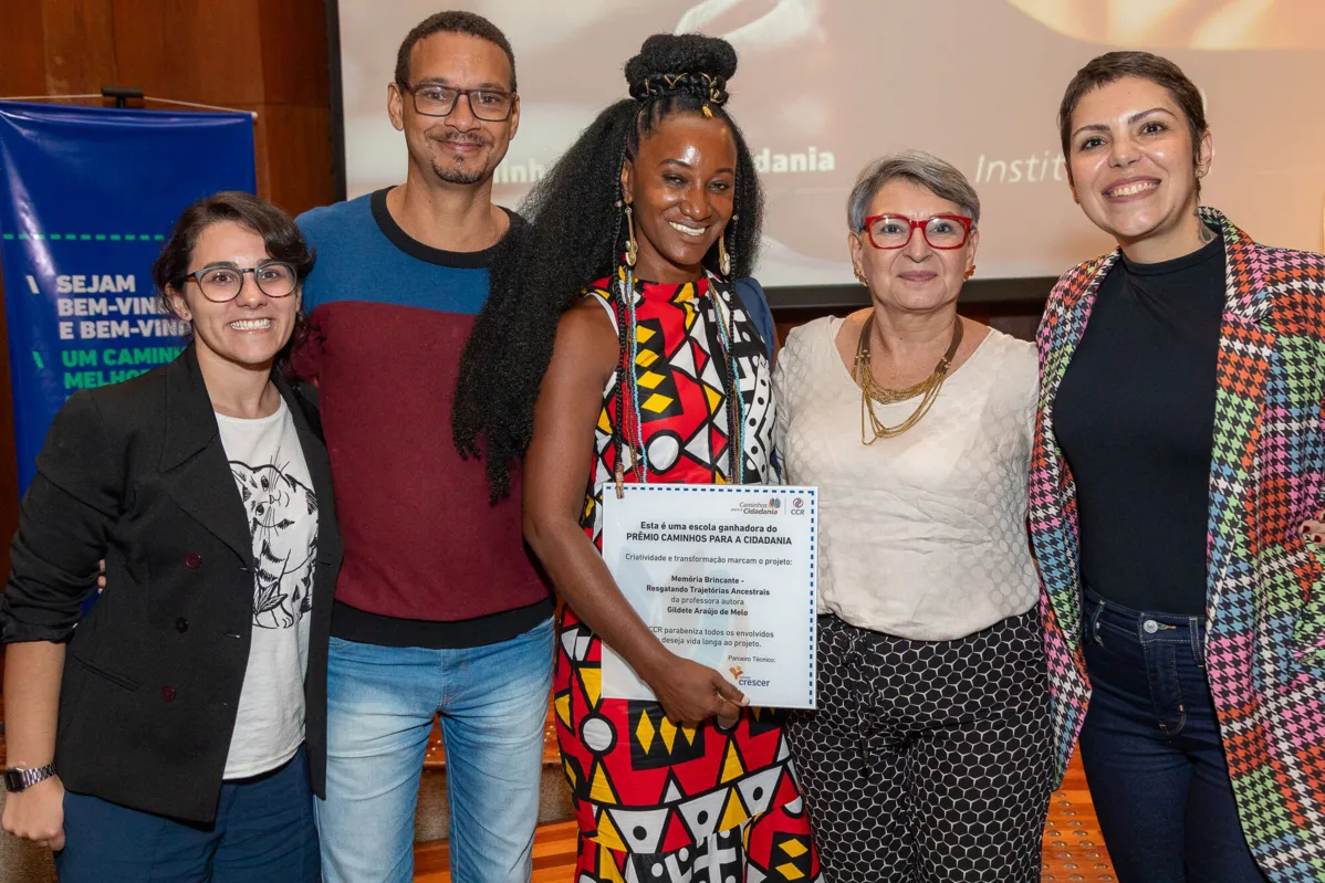Professora Gildete Melo ( ao centro) com o certificado de premiação pelo projeto Memória Brincante