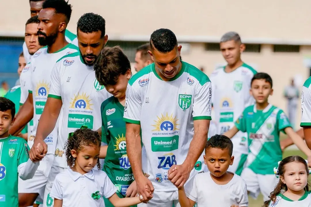 Jogadores do Vitória da Conquista entrando em campo ao lado de crianças na Série B de 2023