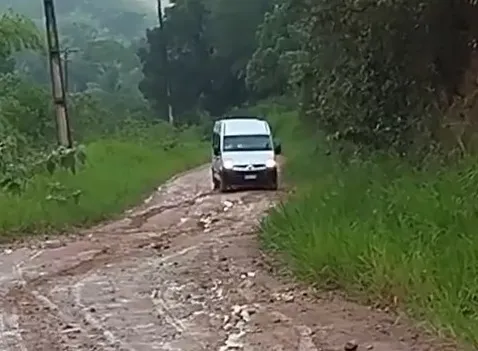 Van de transporte de prtofessores não conseguiu subir rua sem calçamento tomada pela lama.